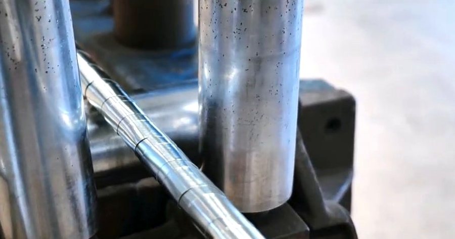 Close-up of an extrusion head forming the outer sheath over a cable core